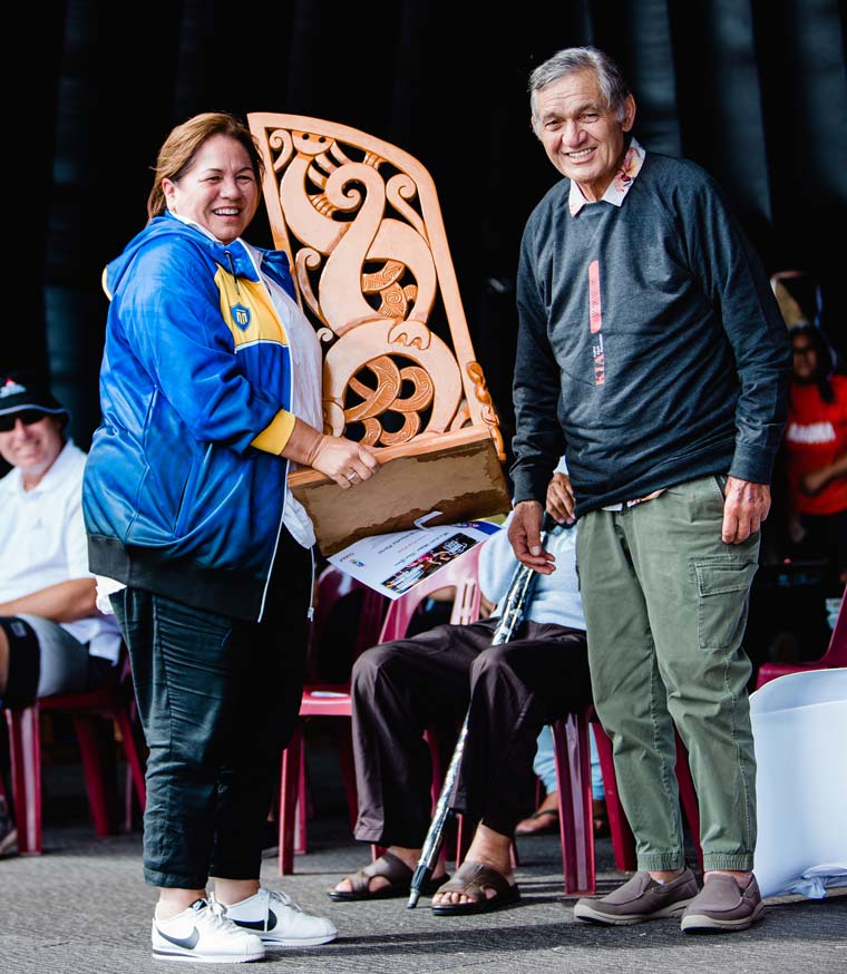 A woman holding a trophy with Kiingi Tuuheitia.